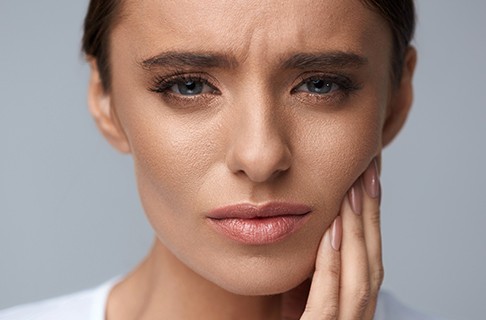 Woman with toothache holding jaw in pain